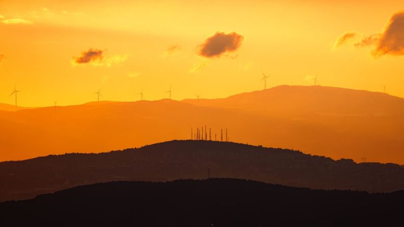 Renewable Energy Innovator - the sun is setting over the hills and windmills