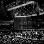 Quantum Vs Classical - grayscale photography of orchestra playing on theatre
