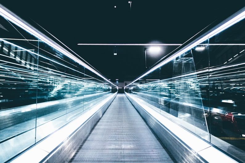 Cyberthreats Future - gray conveyor between glass frames at nighttime