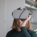 Augmented Glasses - woman in black sweater holding white and black vr goggles
