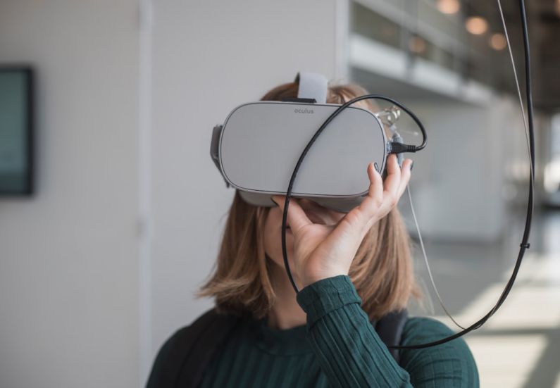 Augmented Glasses - woman in black sweater holding white and black vr goggles