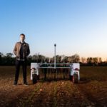 Agriculture Robot - man in black jacket standing on green grass field during daytime