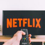 Streaming Service - person holding remote pointing at TV